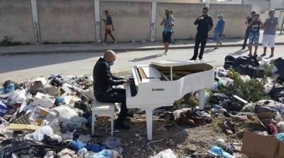 بالصور : يعزف البيانو وسط كومة من النفايات لإجبار البلدية على رفعها في بنزرت 